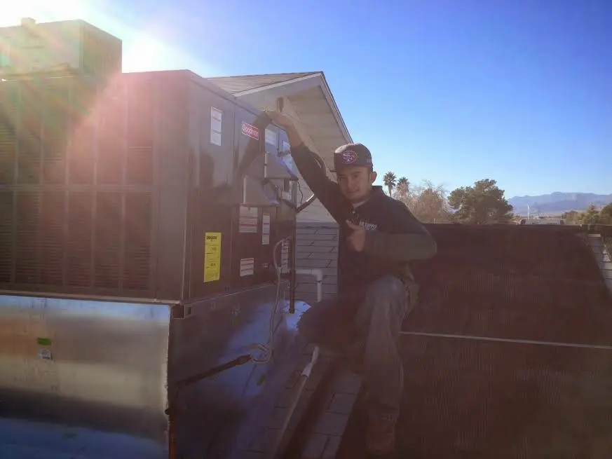 HVAC technician performing Heat Pump Repair on a rooftop unit in Hunters Creek